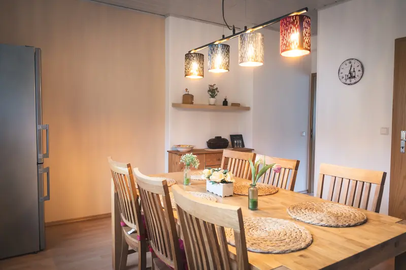 Esstisch aus Holz mit Platzsets und frischen Blumen