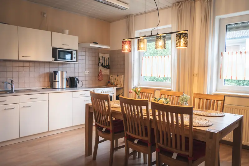 Wohnküche mit Küchenzeile und großem Esstisch aus Holz